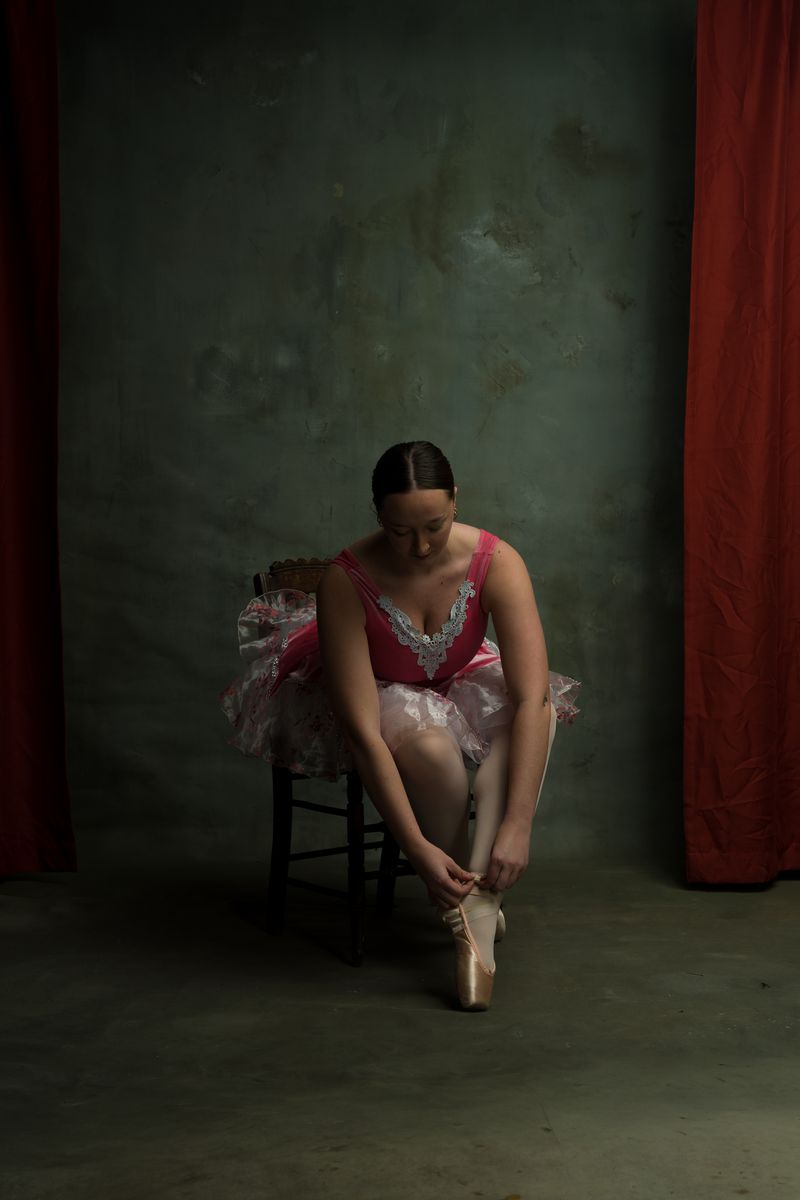 Ballerina tying pointe shoes